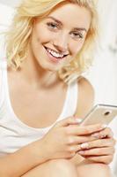 mujer joven enviando mensajes de texto en casa foto