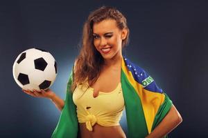 feliz hincha brasileño animando con bandera y fútbol foto