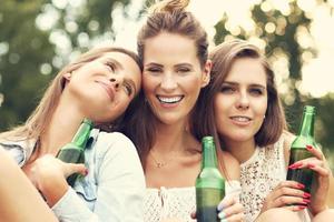 Happy group of friends drinking beer outdoors photo