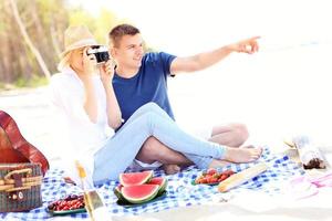 Young couple taking pictures at the beach photo