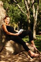 Young pretty woman reading in the park photo