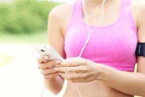 Midsection of a jogger with smartphone photo