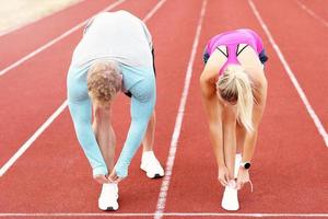 Man and woman racing on outdoor track photo