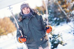 Young handsome man having fun on swing in winter scenery photo