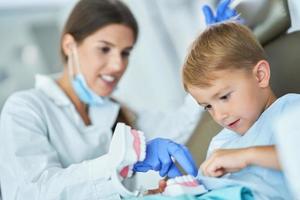 niño pequeño y mujer dentista en la oficina de dentistas foto