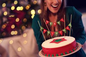 Midsection of woman holding Christmas cake photo