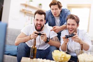 Friends having fun on the couch with video games photo