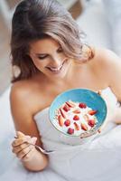 Young woman in underwear eating cereals photo