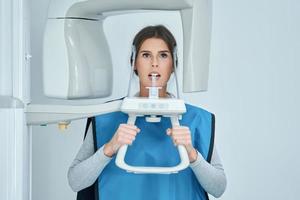 dentista tomando una radiografía digital panorámica de los dientes de un paciente foto