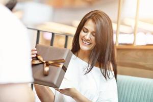 Romantic couple dating in cafe and holding presents photo