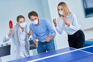 Business people wearing masks relaxing in shared office space photo