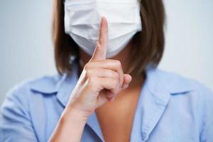 Attractive woman wearing protective mask isolated over white background photo