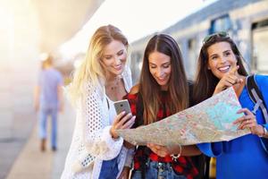 Group of girl friends tourists on railway platform photo
