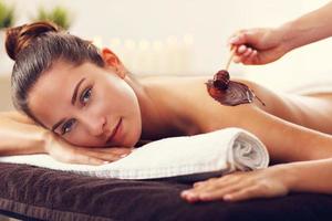 hermosa mujer recibiendo masaje de chocolate en el spa