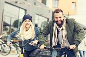 Young couple riding bikes and having fun in the city photo