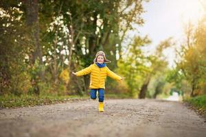 niño feliz niño jugando afuera en otoño foto