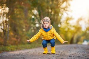 niño feliz niño jugando afuera en otoño foto