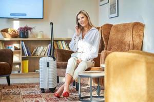 Businesswoman with luggage in modern hotel lobby photo