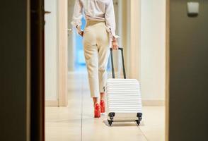 Businesswoman with luggage in modern hotel lobby photo