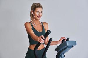Woman exercising at the gym on crosstrainer photo