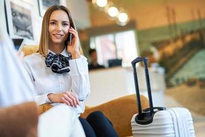 Two businesswomen with luggage in modern hotel lobby photo