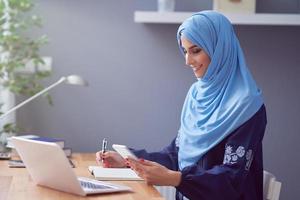 Muslim adult woman using smartphone photo