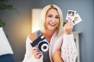 Adult beautiful woman taking instant photo at home