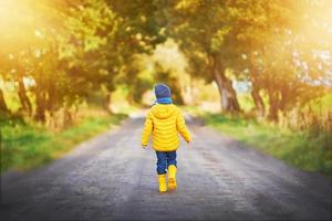 Happy child boy playing outside in autumn photo