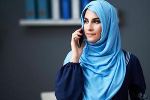 Muslim adult woman using smartphone photo