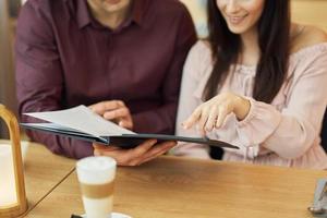 Young Couple looking at menu In Cafe photo