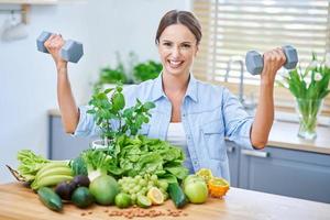 Healthy adult woman with green food in the kitchen photo