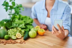 Healthy adult woman with green food in the kitchen photo