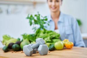 Healthy adult woman with green food in the kitchen photo