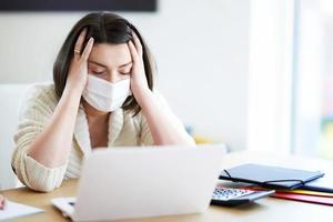 Exhausted mother trying to work at home during coronavirus pandemic photo