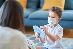 Mother and child playing together at home isolation during coronavirus pandemic photo