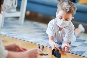 Mother and child playing together at home isolation during coronavirus pandemic photo