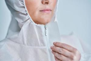 Woman in bio-hazard suit on white background. photo