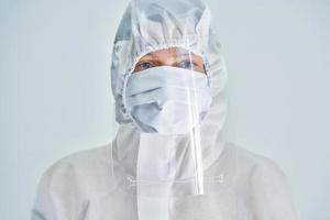 Woman in bio-hazard suit and face shield on white background. photo