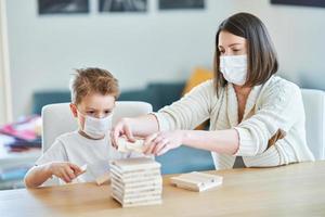 Mother and child playing together at home isolation during coronavirus pandemic photo