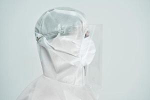 Woman in bio-hazard suit and face shield on white background. photo