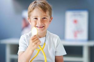 A little doctor with stethoscope smiling in doctor's office photo