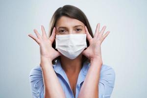 Attractive woman wearing protective mask isolated over white background photo