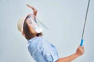 Woman tourist wearing protective shield taking selfie on white background photo