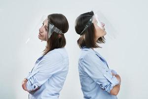 Attractive woman wearing protective shield thinking over white background photo