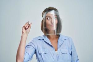 Attractive woman wearing protective shield writing over white background photo