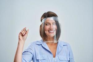 Attractive woman wearing protective shield writing over white background photo