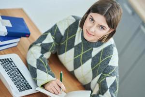 Teenage girl having online classes at home photo