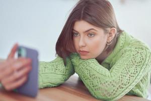 adolescente enviando mensajes de texto en casa foto