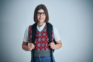 Happy young positive student posing over bright background photo