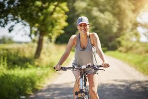 joven mujer feliz en bicicleta en el campo foto